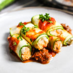 Photo of plate with zucchini rollatini and red meat sauce.