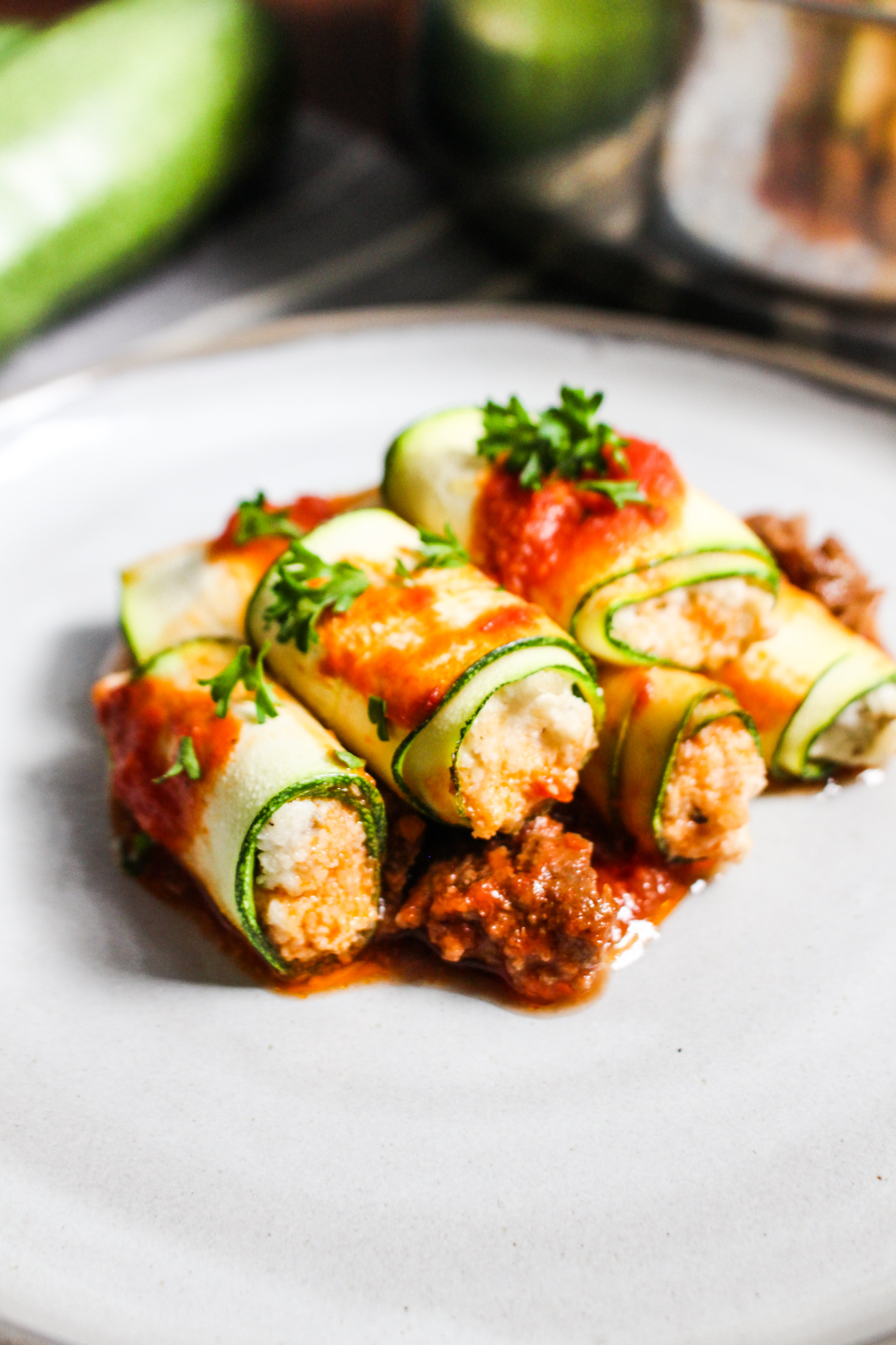 Photo of plate with zucchini rollatini and red meat sauce.