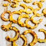 roasted delicata squash half moons on baking sheet