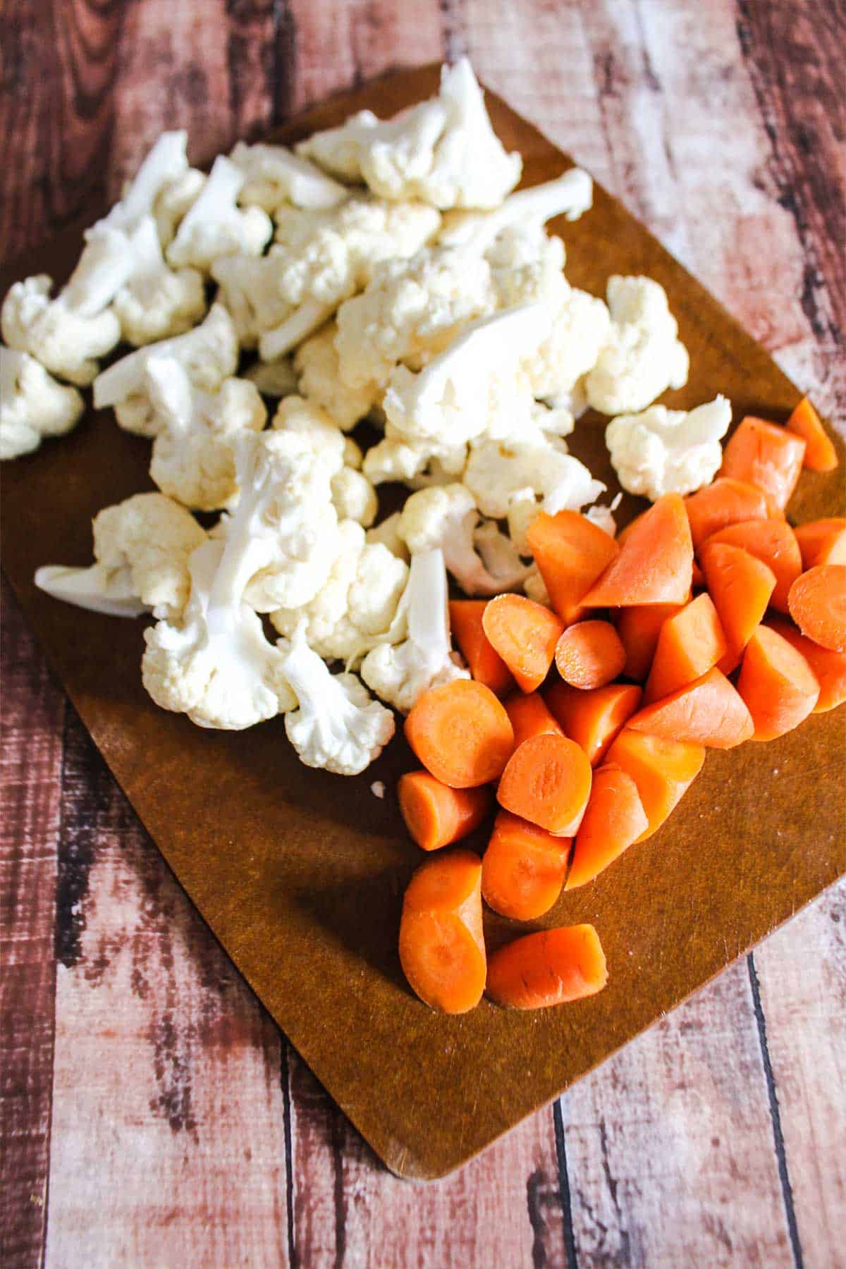 Cut veggies on a cutting board ready to add to sheet pan.