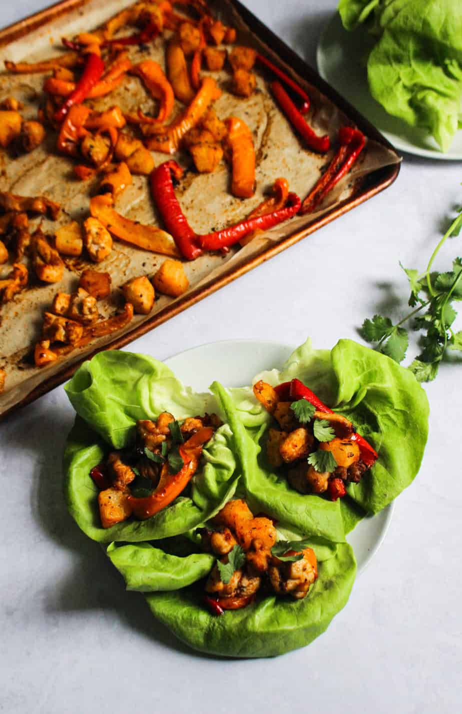 three lettuce wraps on a plate with filling