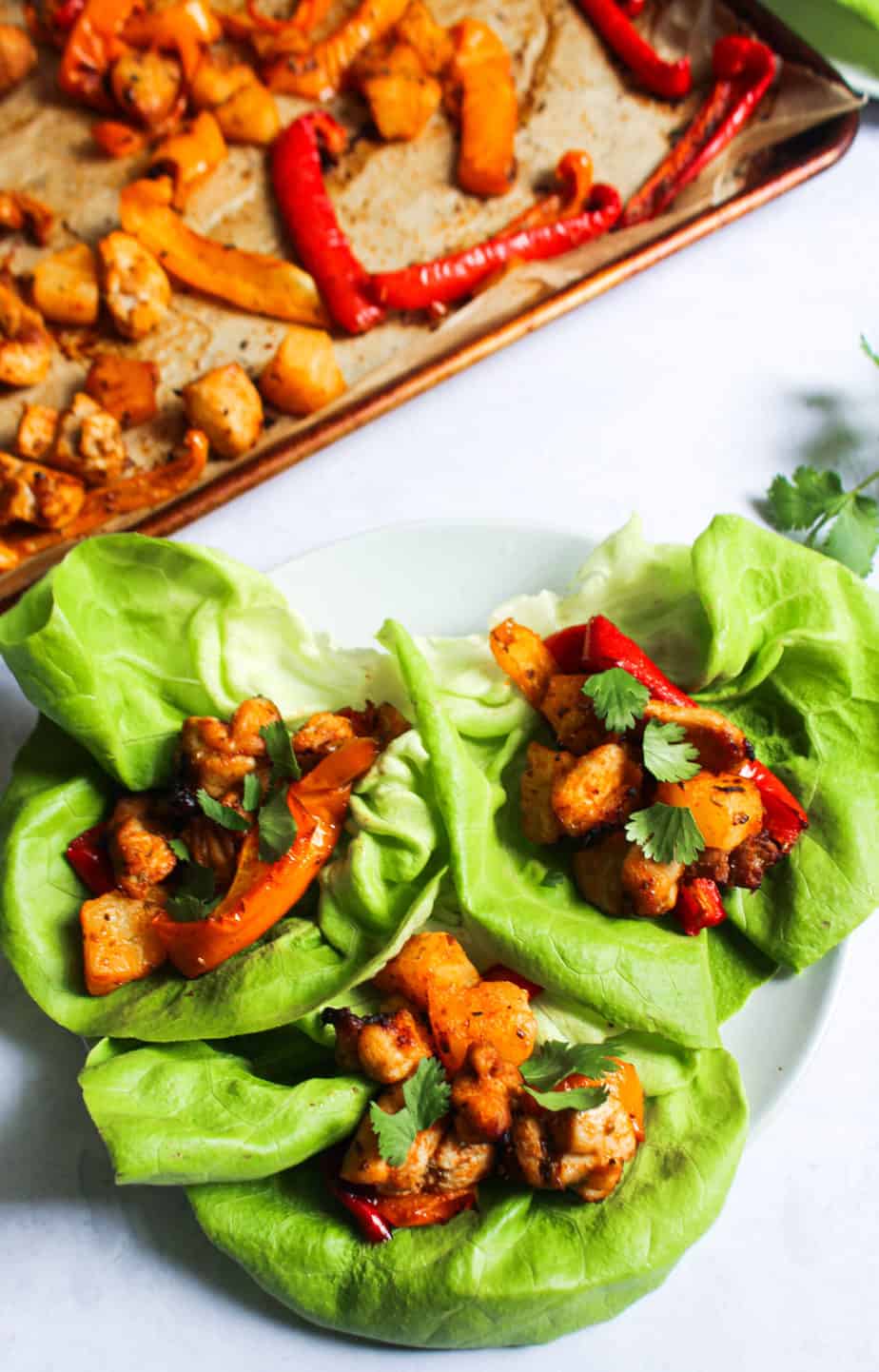 three lettuce wraps on a plate with filling