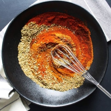 Spices to make chorizo seasoning in a bowl with a small whisk.