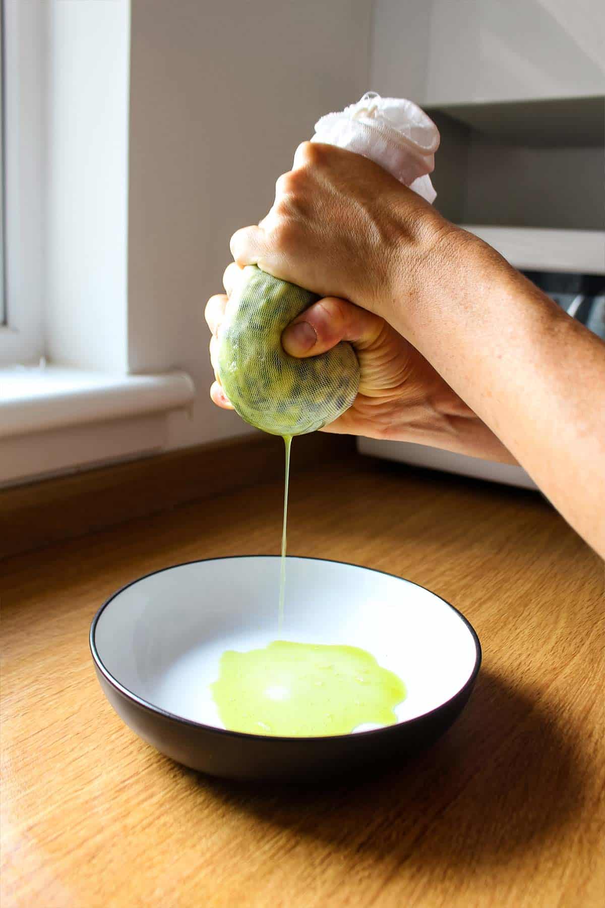 Squeezing the zucchini in cheesecloth.