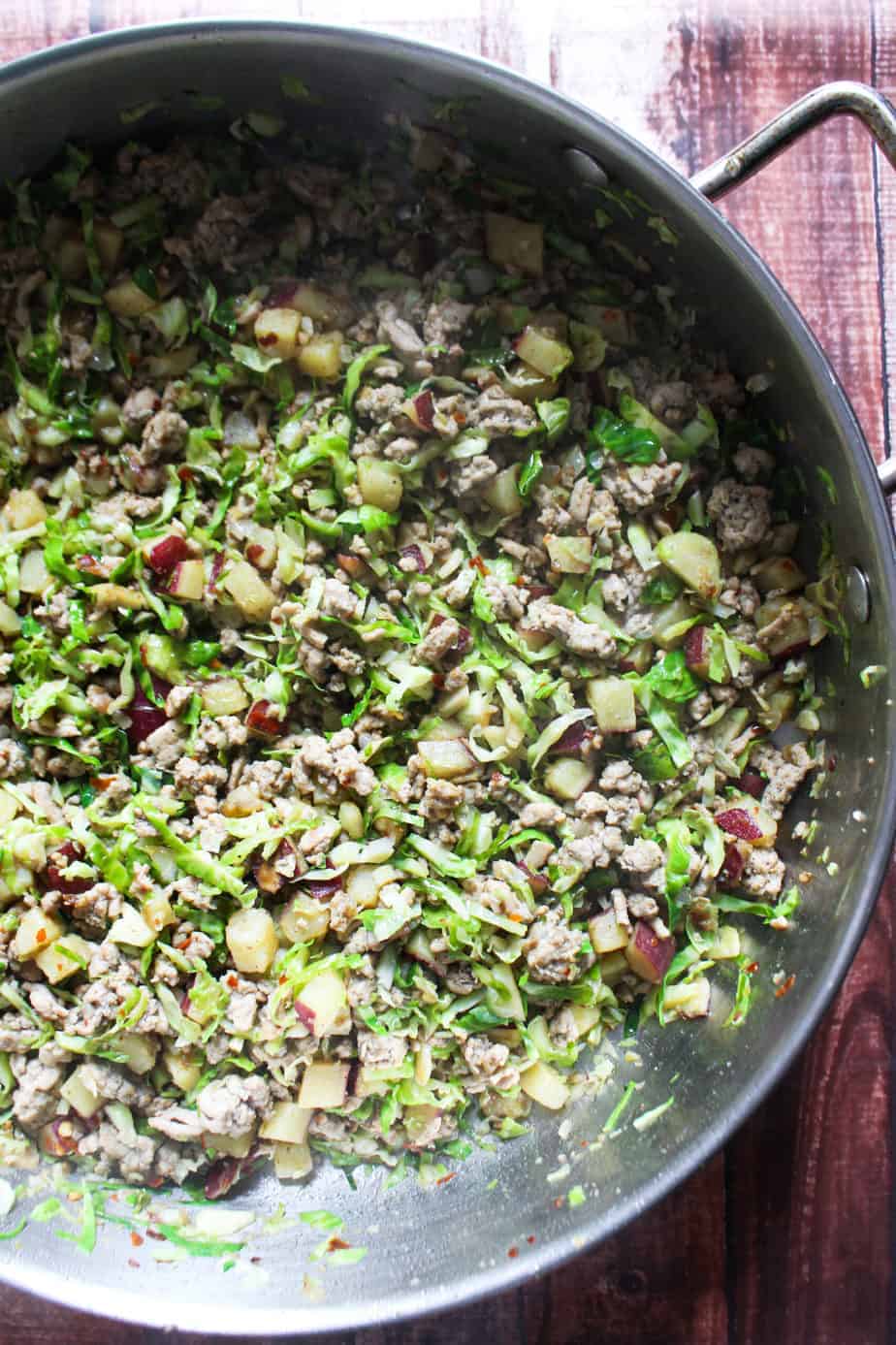 skillet with ground turkey, shredded brussels sprouts, and Japanese sweet potatoes