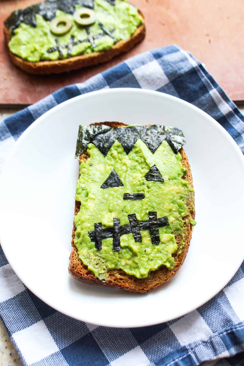 avocado toast decorated with nori to look like frankenstein