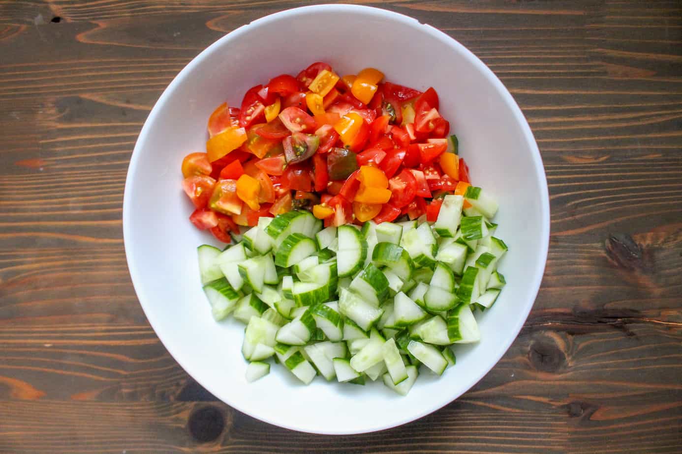 Cut up cucumber and tomatoes for lamb gyro wraps