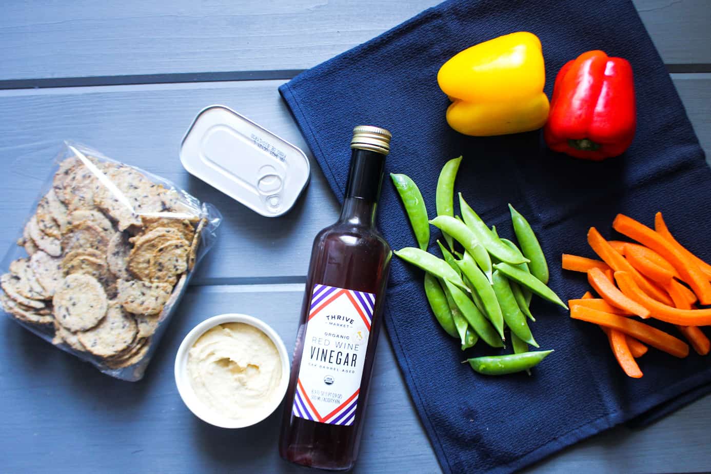 crackers, hummus, canned mackerel, red wine vinegar, snap peas, 1 yellow bell pepper, 1 red bell pepper, and carrot sticks
