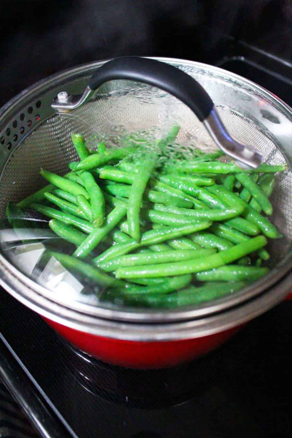 Green beans steaming in a pot to serve with slow cooker pork chops.