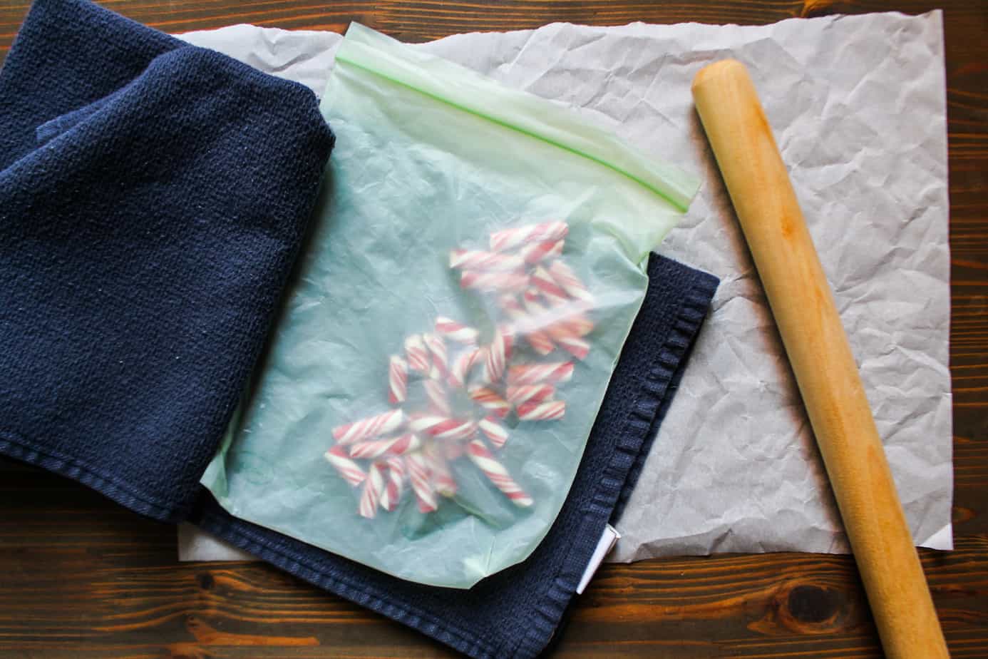 broken candy canes in zip top bag with rolling pin for smashing