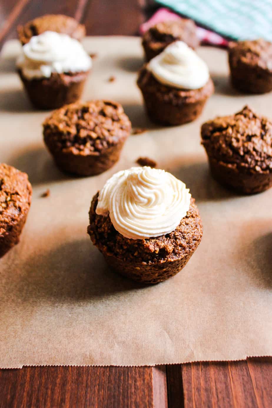 gingerbread muffins with cream cheese frosting on parchment paper