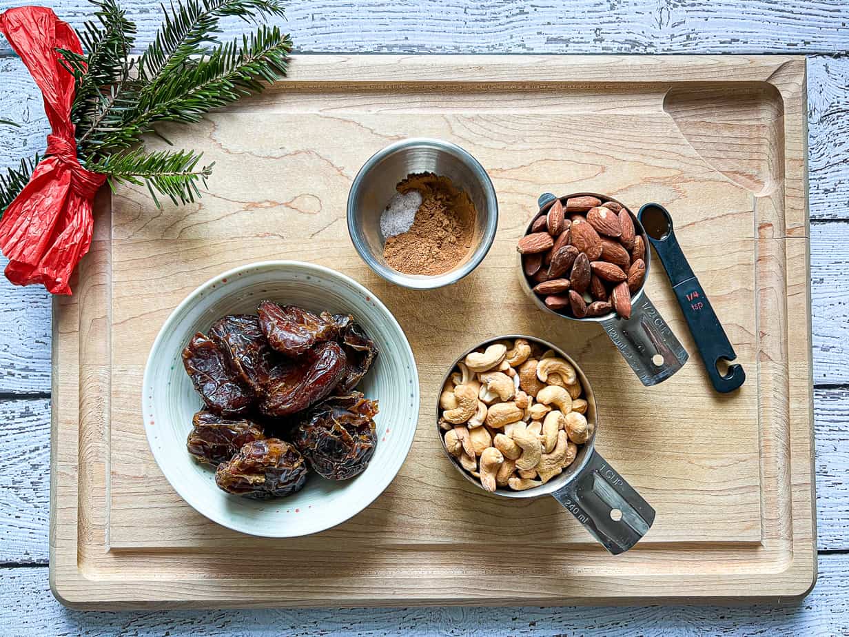 cutting board with dates, cashews, almonds, and cinnamon