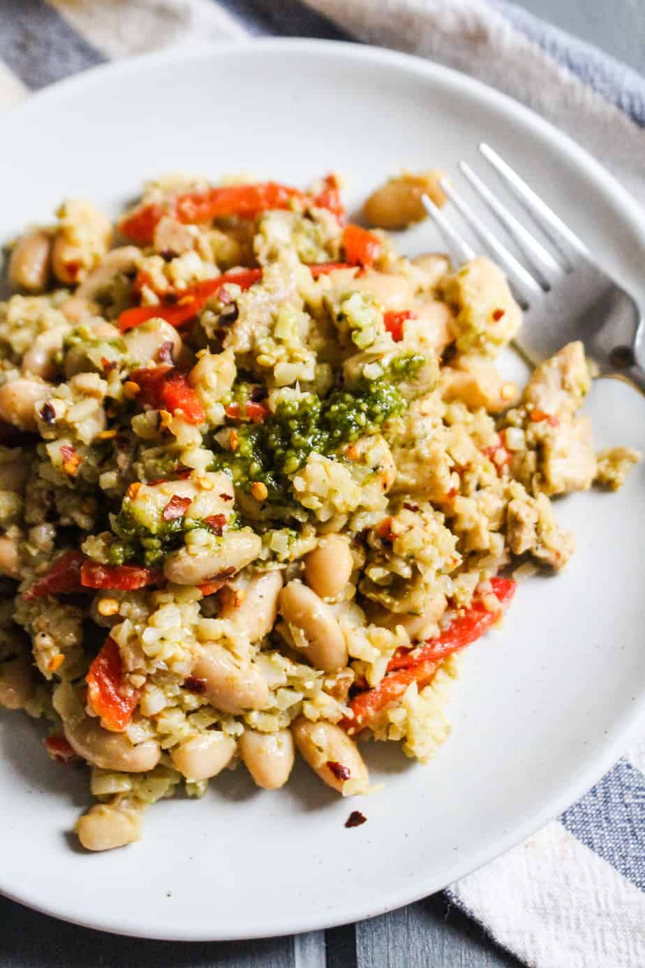 chicken pesto skillet dish on a plate, topped with more pesto