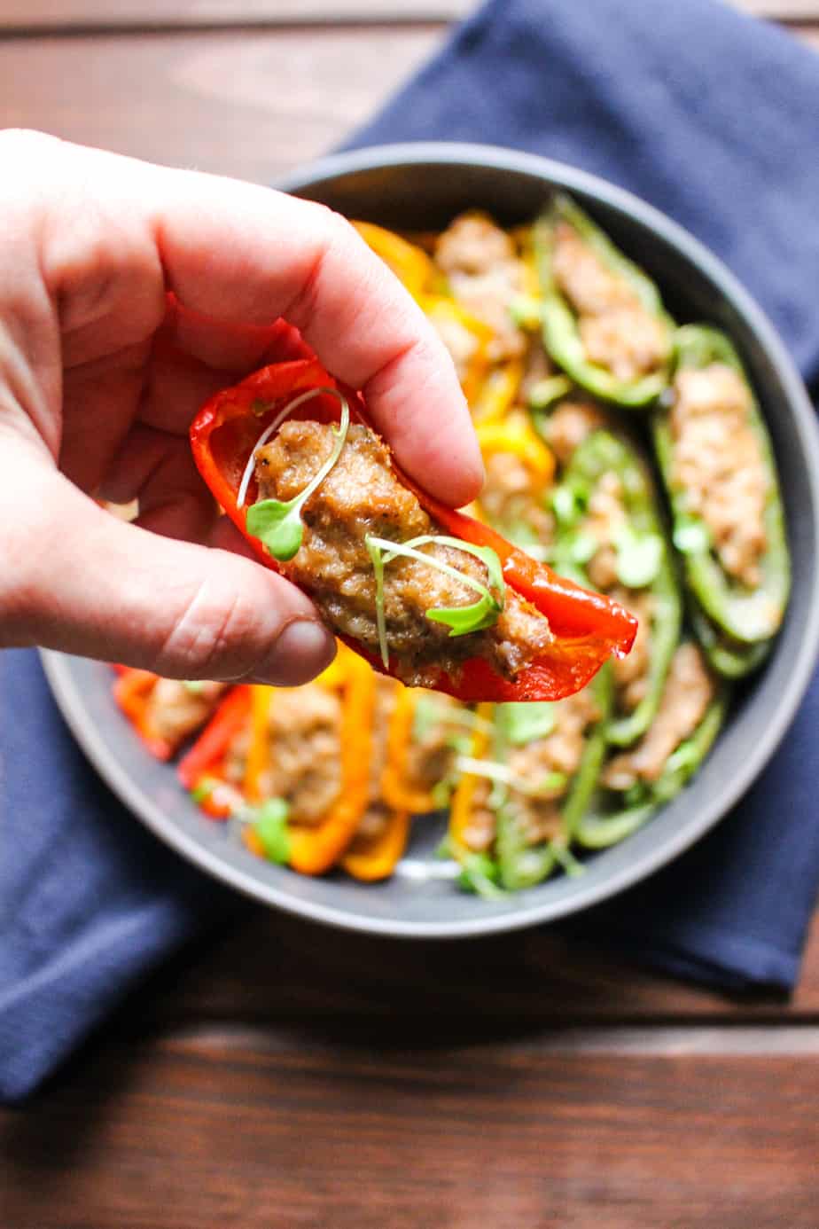 hand holding a red mini pepper stuffed with sausage