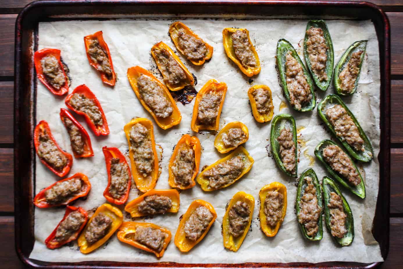 sheet pan with cooked sausage stuffed mini peppers