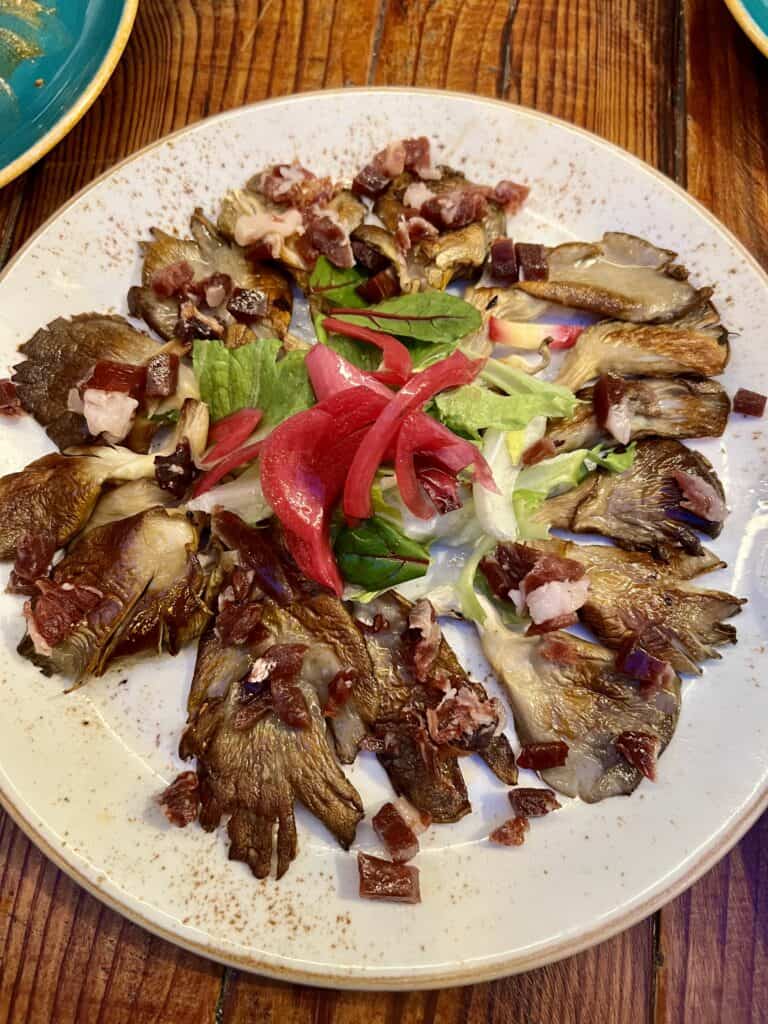 white plate with cooked oyster mushrooms
