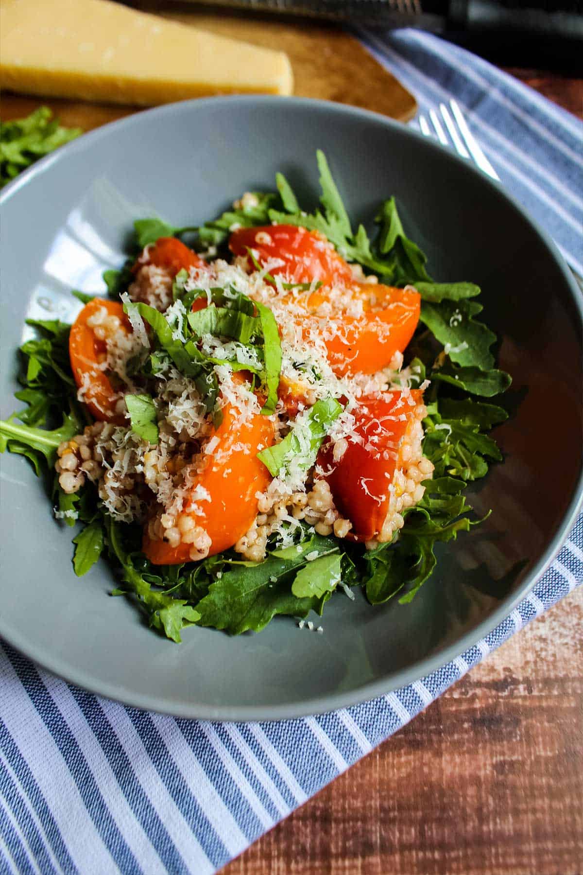 Sorghum served up in a bowl with tomatoes and fresh basil.