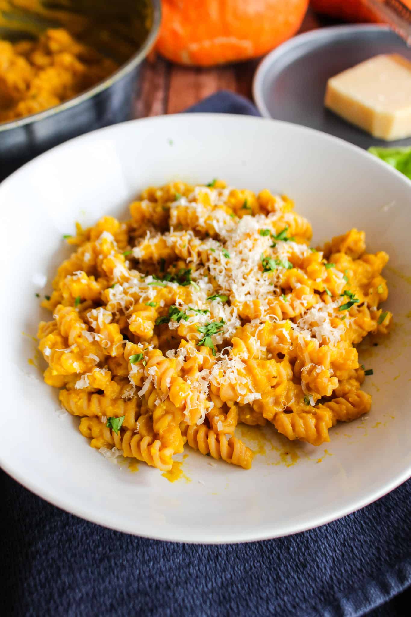 Pumpkin pasta sauce on rotini noodles and garnished with parmesan.