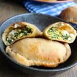 a breakfast calzone cut open on top of another calzone on a plate