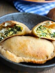 a breakfast calzone cut open on top of another calzone on a plate