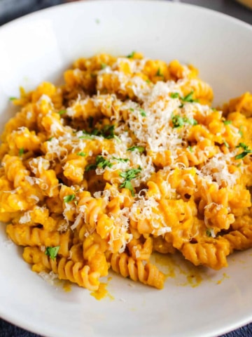A bowl of pasta tossed with pumpkin pasta sauce.