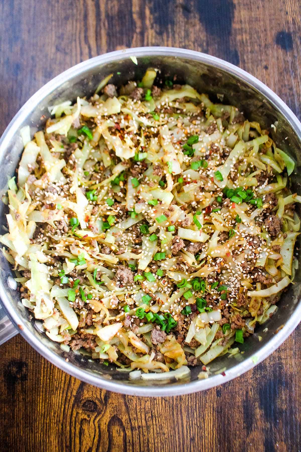 Ground beef and cabbage cooked in a skillet.