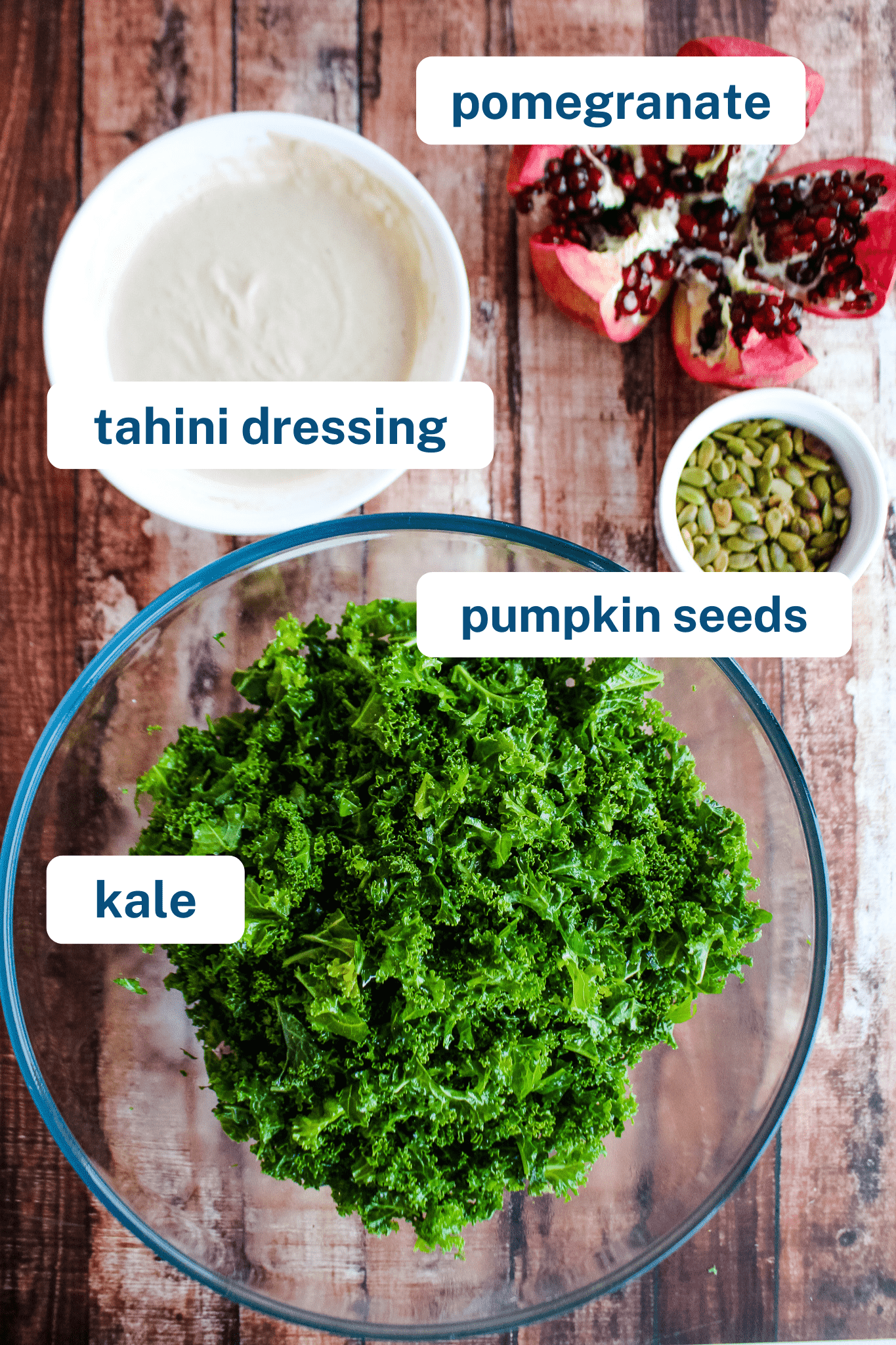 open pomegranate, smooth tahini dressing, pumpkin seeds, and a bowl of massaged kale