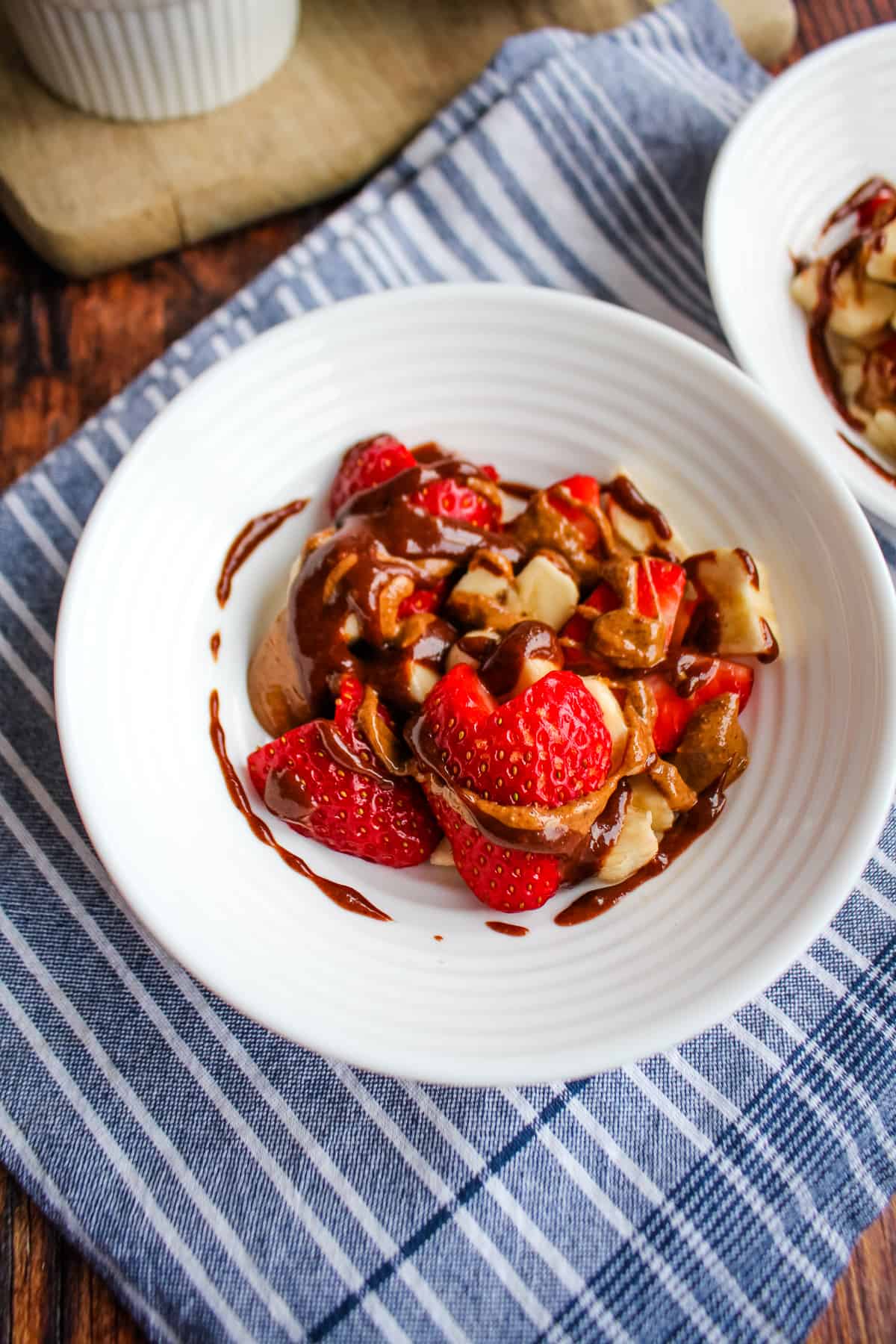 Bowl of heart shaped bananas, heart shaped strawberries drizzled with chocolate spread and almond butter.