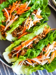Pork lettuce wraps served up on a gray plate on the table.