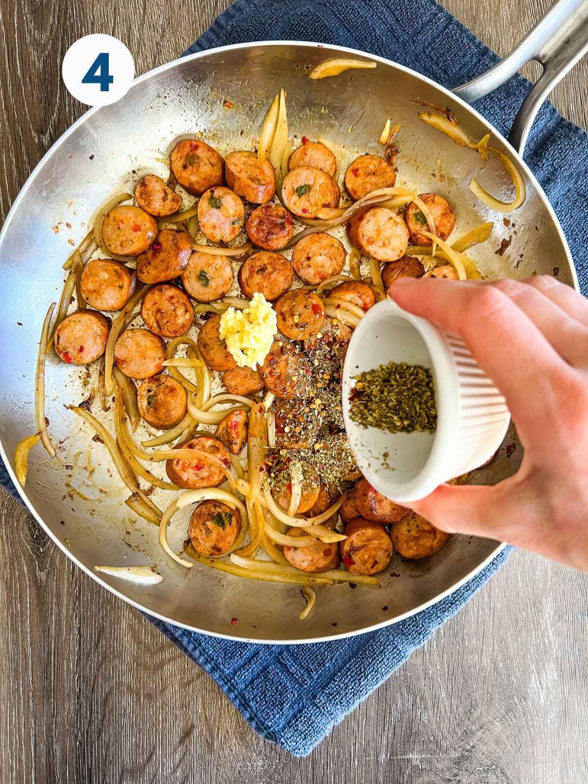 Adding spices to the skillet of sausage and onions.