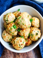 A bowl of japanese meatballs on the table with a blue tea towel.