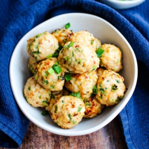 A bowl of japanese meatballs on the table with a blue tea towel.