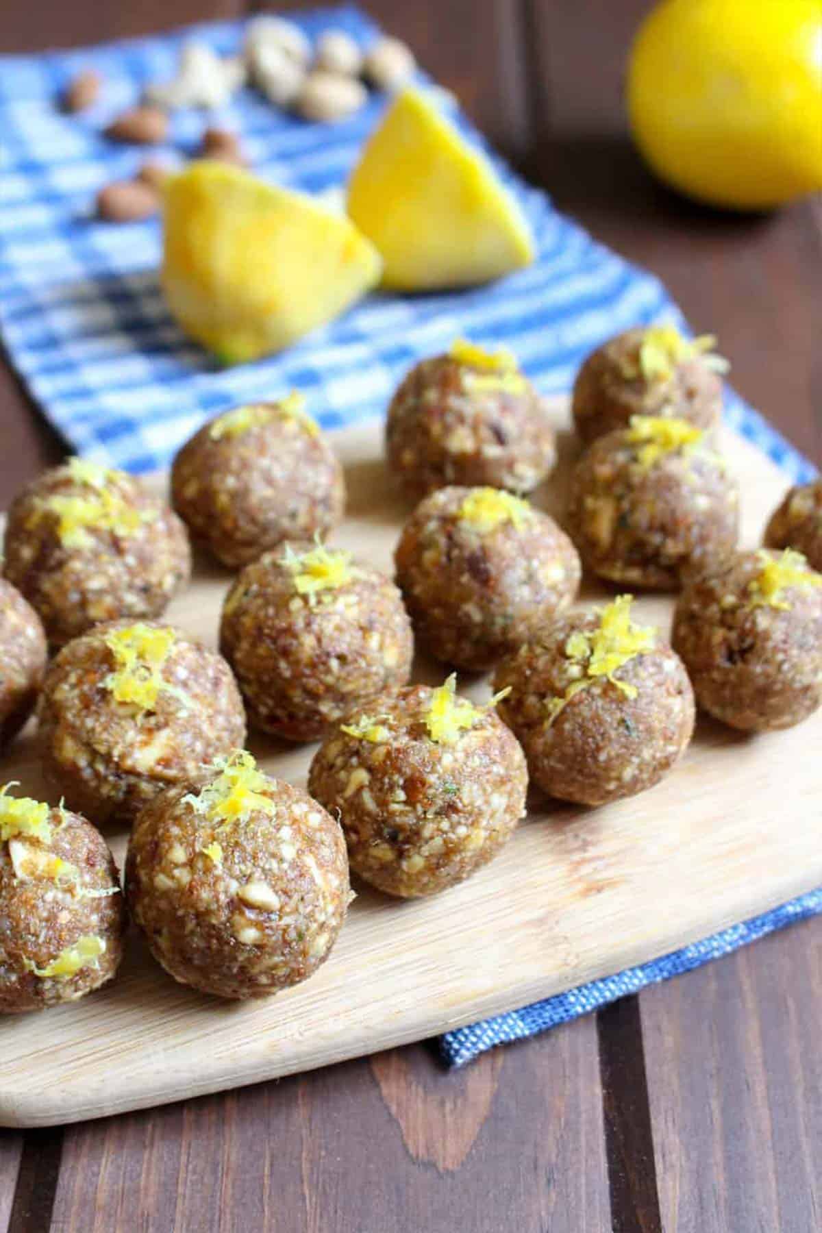 Lemon date bites on the table with fresh lemon in the background.