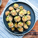 A plate of salmon onigiri seaweed rolls on a plate.