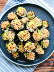 A plate of salmon onigiri seaweed rolls on a plate.