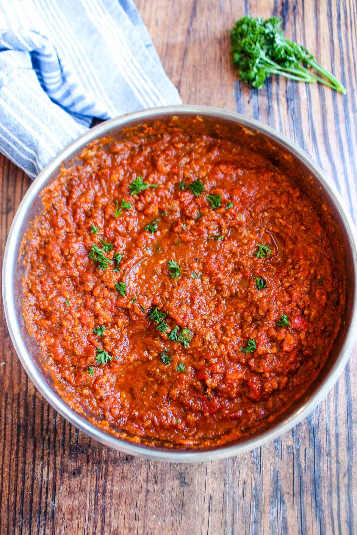 Sausage mushroom bolognese sauce in a skillet garnished with parsley.