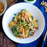 Soba noodles and veggies with a spicy peanut sauce in a bowl.