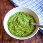 Spinach pesto in a bowl with a spoon in it.