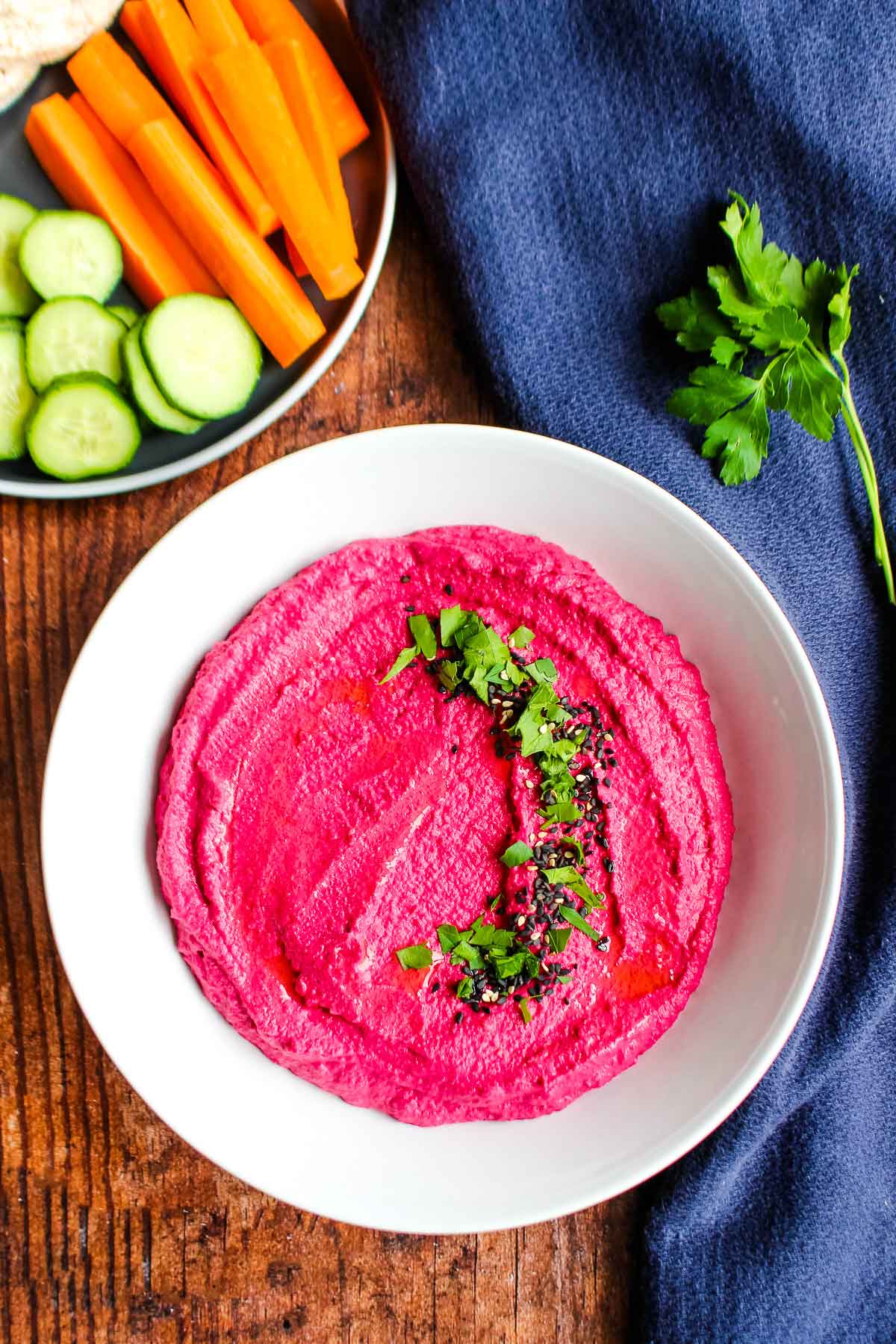 A bowl of beet and white bean hummus on the table.