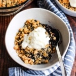 Gluten free blueberry crisp served with ice cream in a bowl.