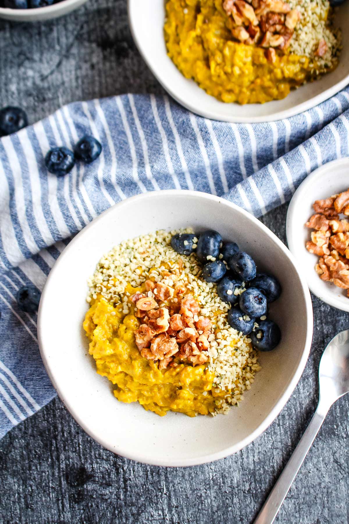 A bowl of golden milk oatmeal on the table with toppings added.