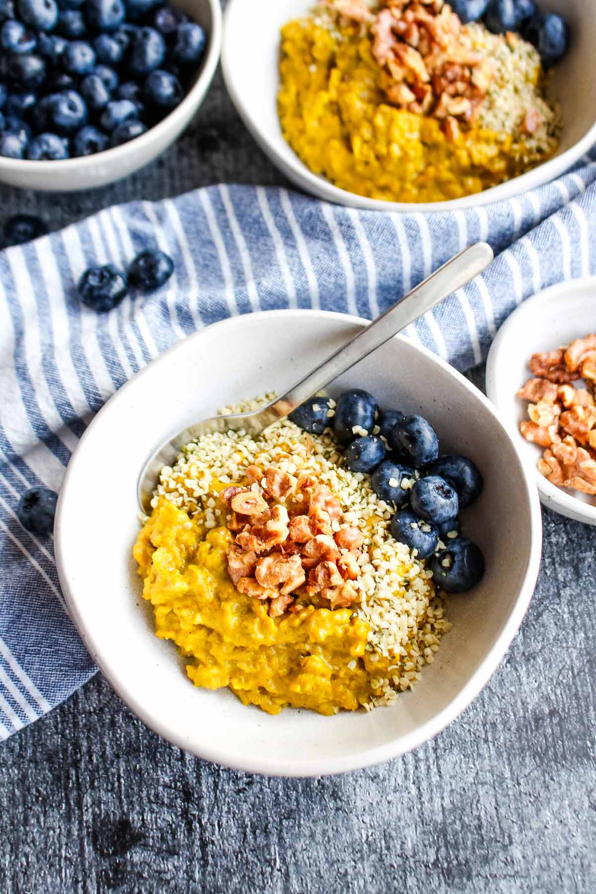 A bowl of golden milk oatmeal on the table with a spoon.