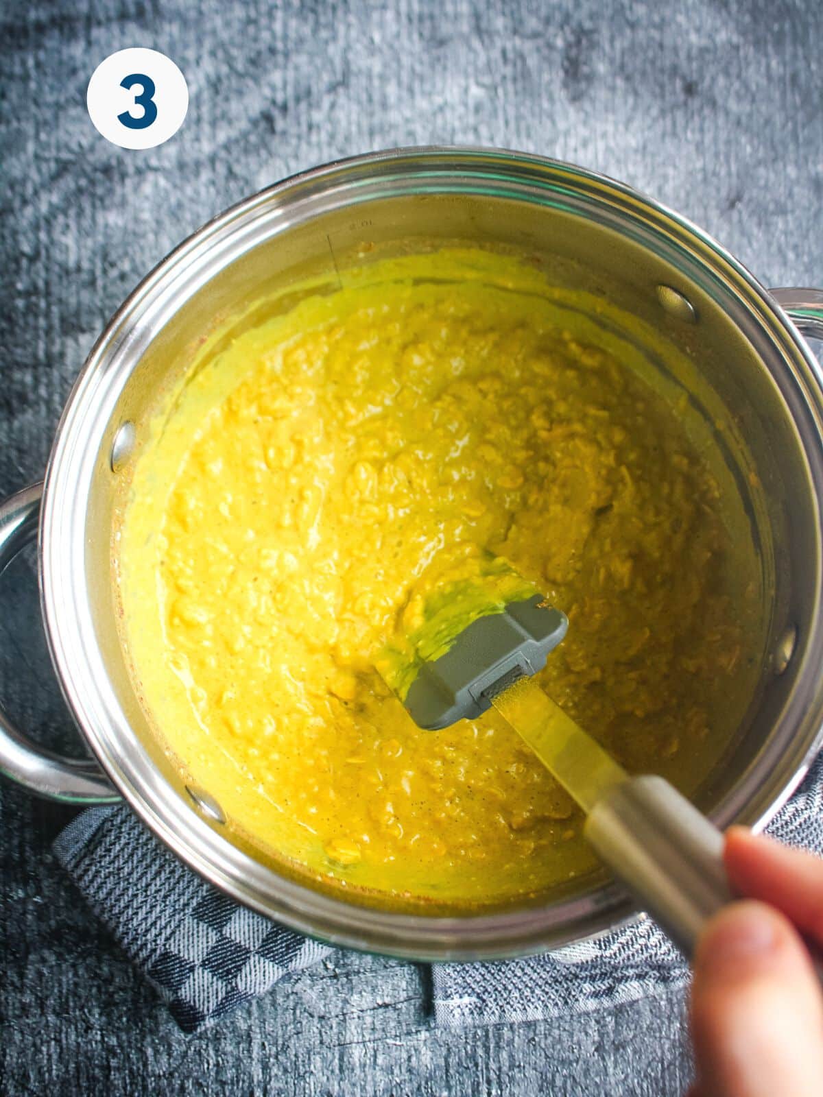 Stirring the golden milk oatmeal while it's cooking.