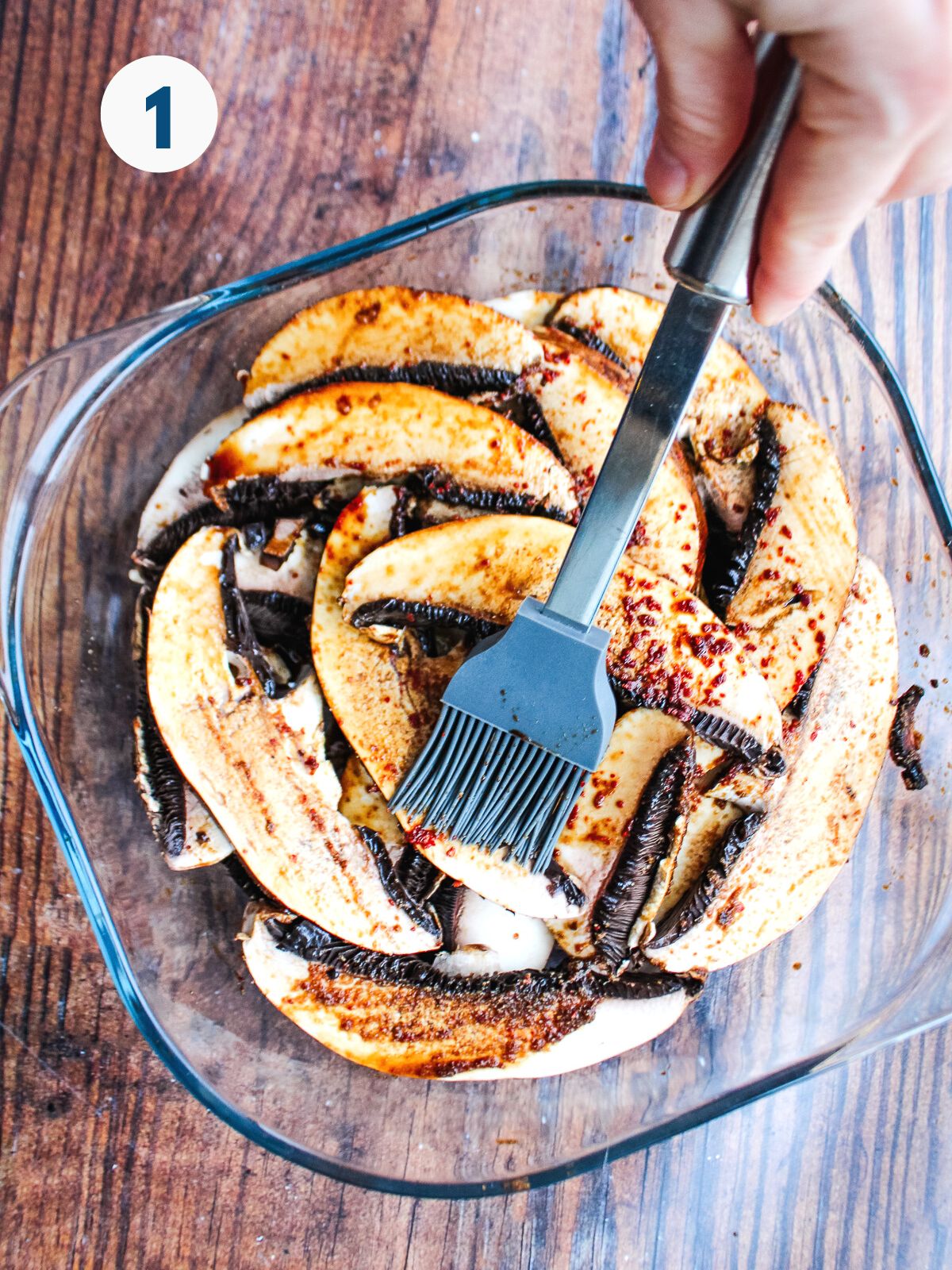 Brushing the sliced portobello mushrooms with marinade.