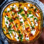 Twice baked mashed potato casserole on the table with a blue napkin.