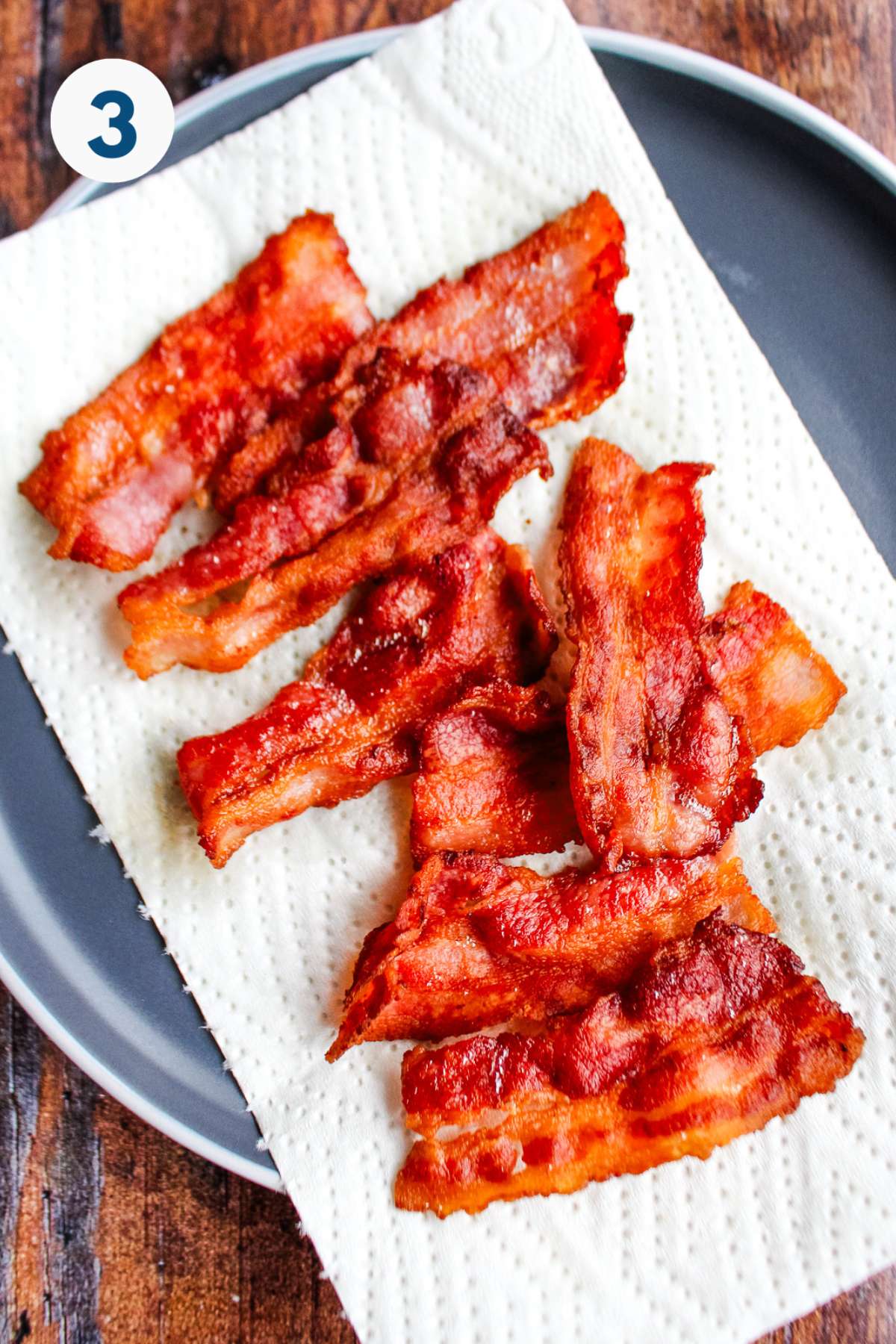 Cooked bacon draining on paper towels.