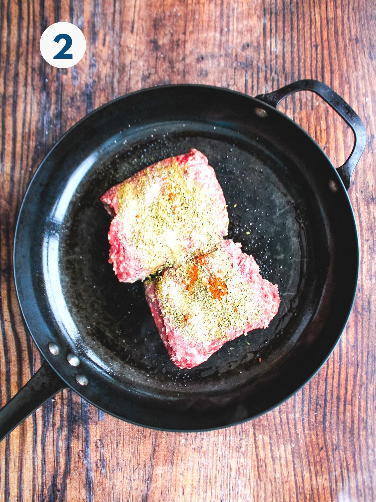 Beef and spices in a skillet.