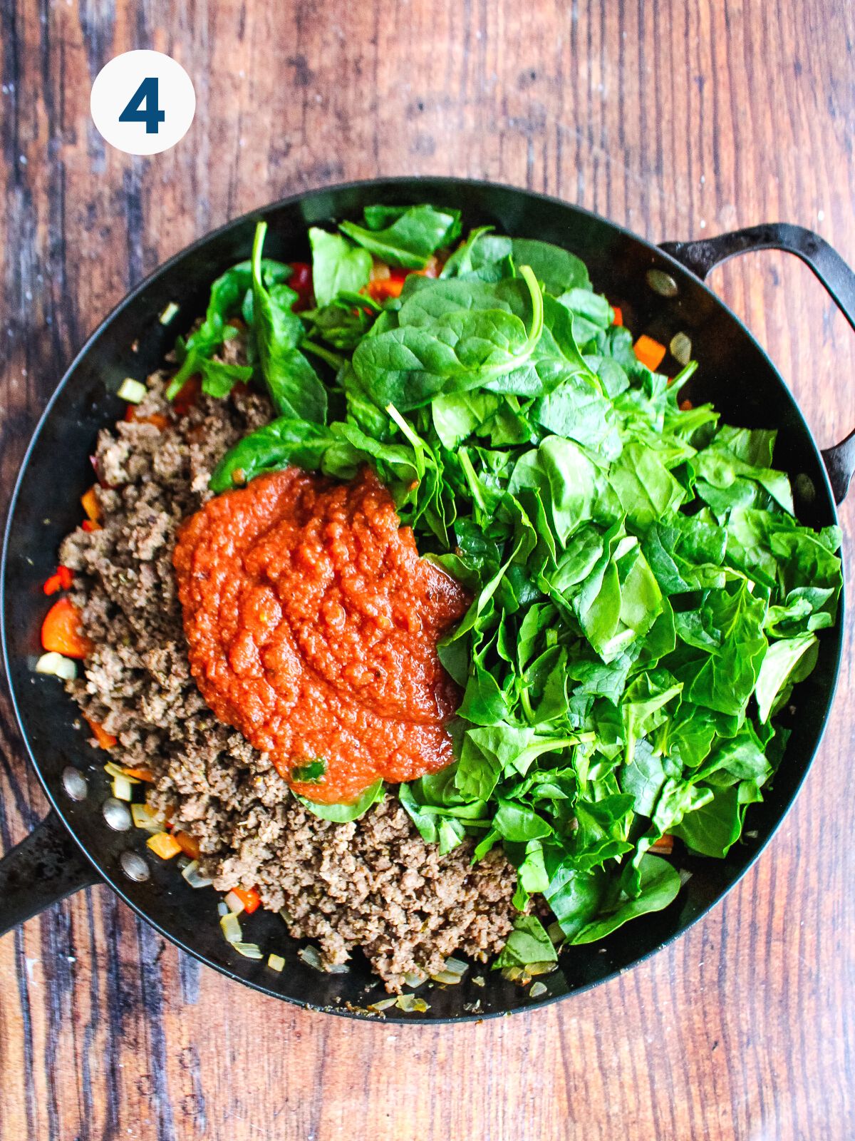 Adding the beef, spinach, and salsa to the skillet.