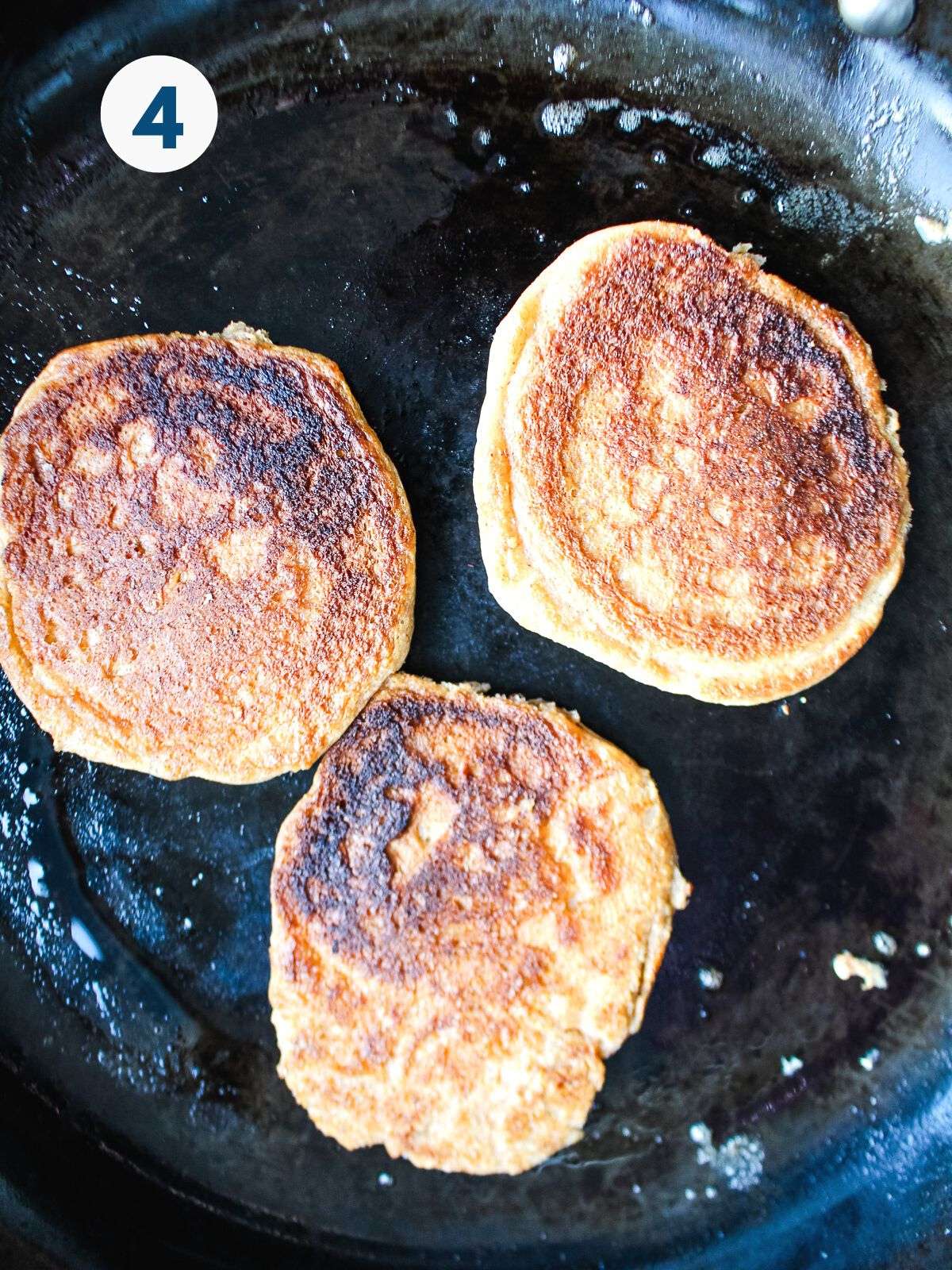 Cottage cheese pancakes flipped in a pan.