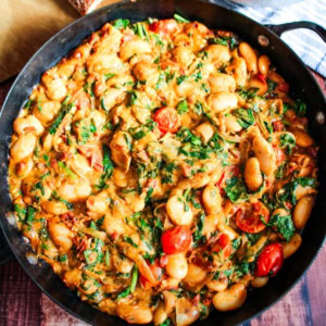 Marry me butter beans in a skillet garnished with parsley.
